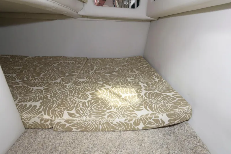 Slide: The Image of 2021 Crownline 264 CR cabin interior with patterned cushions and carpeted flooring. - 15