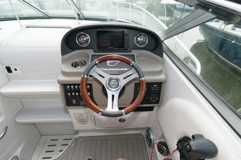 Slide: The Image of 2021 Crownline 264 CR boat dashboard with steering wheel and control panel. - 5