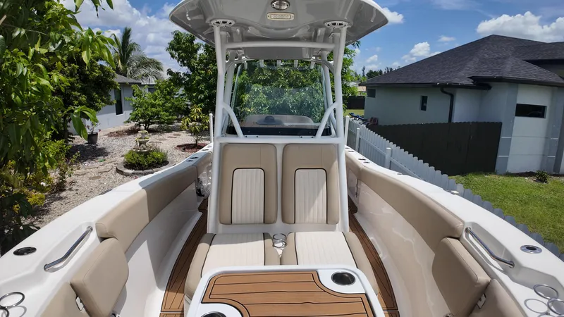 Slide: The Image of 2017 Sea Fox 266 Commander boat with beige seating and wood accents, parked outdoors. - 26