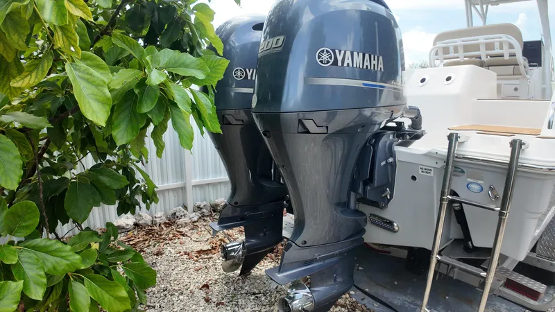 Slide: The Image of 2017 Sea Fox 266 Commander with dual Yamaha outboard motors, parked near greenery. - 30