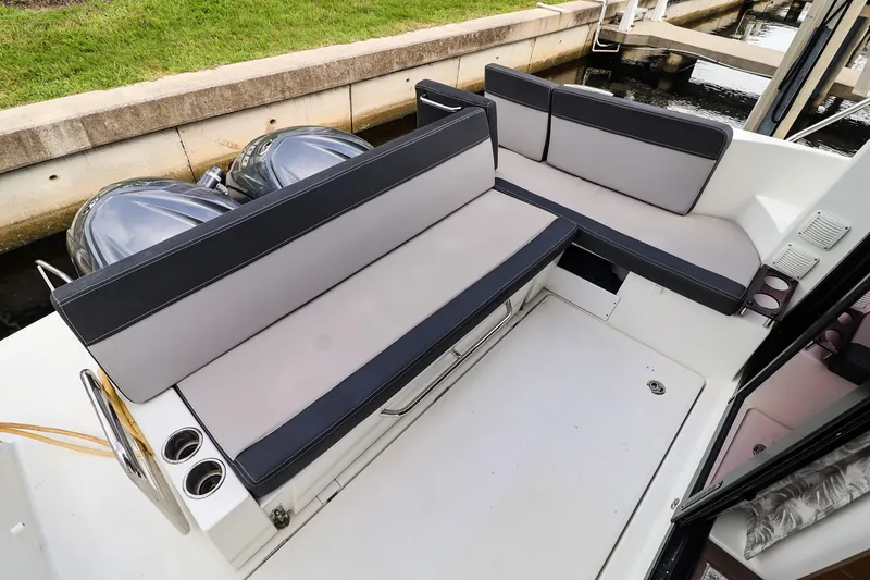 Slide: The Image of 2021 Jeanneau NC 1095 boat with cushioned seating and dual outboard motors. - 12