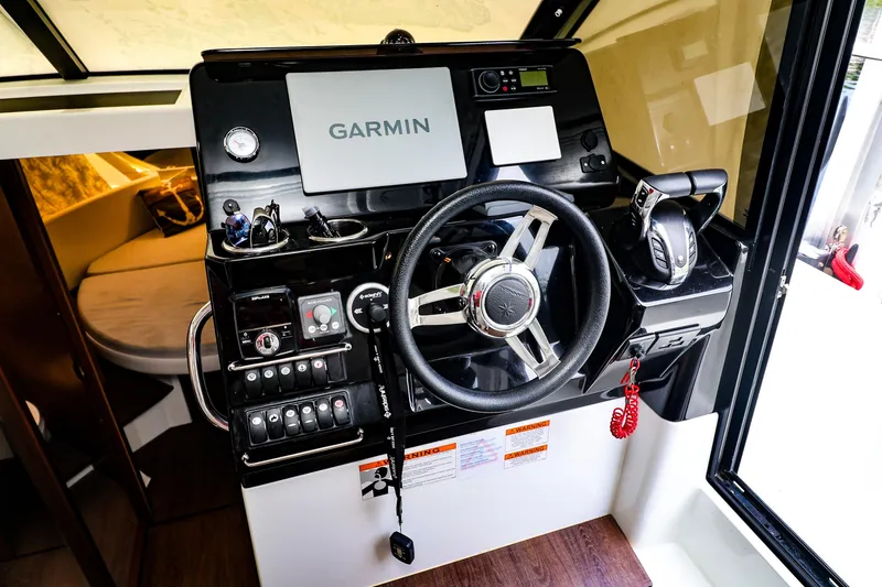 Slide: The Image of Helm station of 2021 Jeanneau NC 1095 with Garmin navigation system and controls. - 15