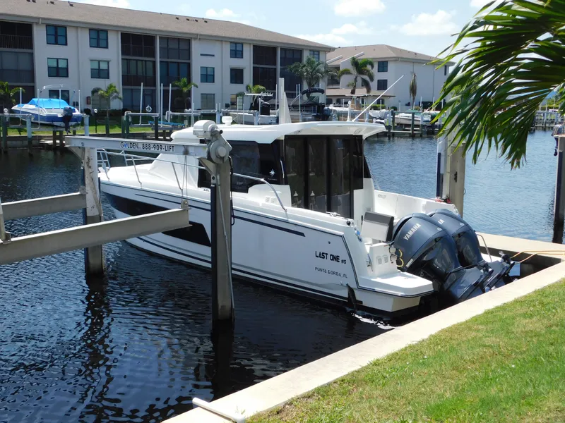 Slide: The Image of 2021 Jeanneau NC 1095 boat docked in a marina, surrounded by residential buildings. - 2