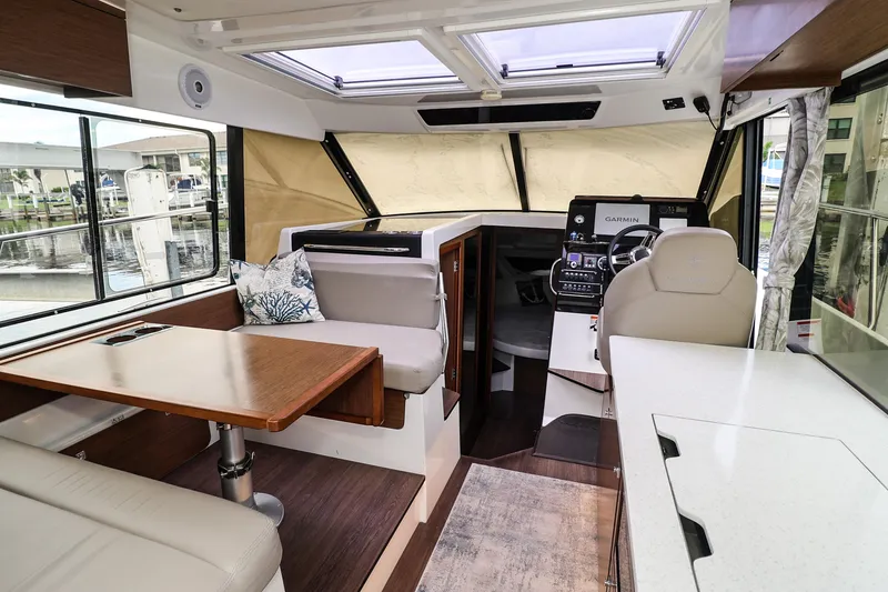 Slide: The Image of Interior of 2021 Jeanneau NC 1095 boat with modern seating and navigation area. - 22