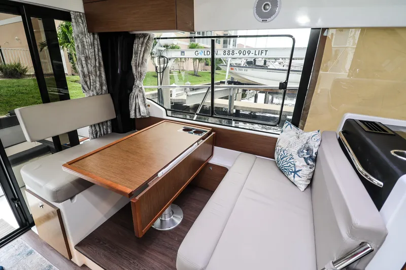Slide: The Image of Interior of 2021 Jeanneau NC 1095 boat with dining area and window view. - 24