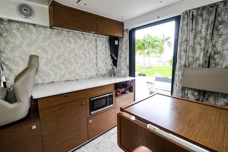 Slide: The Image of Interior of 2021 Jeanneau NC 1095 boat with modern kitchen and outdoor view. - 26