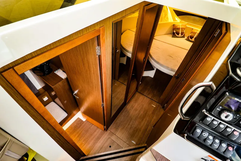 Slide: The Image of Interior view of 2021 Jeanneau NC 1095 boat cabin with wooden doors and cozy sleeping area. - 29