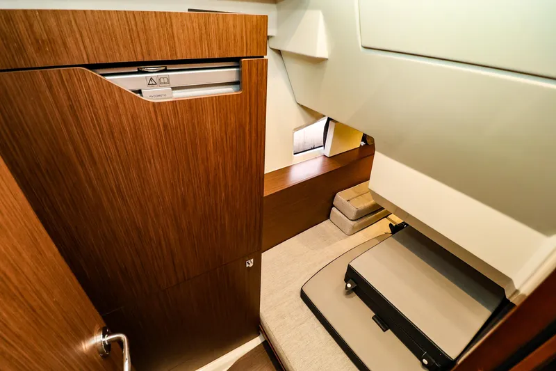 Slide: The Image of 2021 Jeanneau NC 1095 cabin interior with wood finish and compact design. - 34