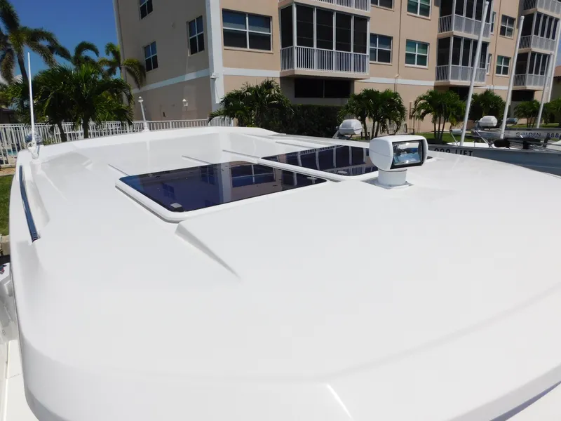 Slide: The Image of 2021 Jeanneau NC 1095 boat roof with solar panels and radar, near modern buildings. - 37