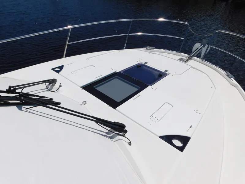 Slide: The Image of 2021 Jeanneau NC 1095 boat deck with hatch, railing, and wipers on calm water. - 39