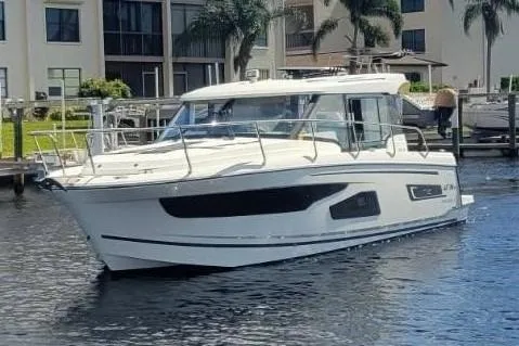 Slide: The Image of 2021 Jeanneau NC 1095 boat on water near waterfront buildings. - 2
