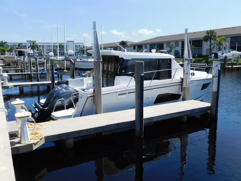 Slide: The Image of 2021 Jeanneau NC 1095 docked at marina with twin outboard engines. - 5