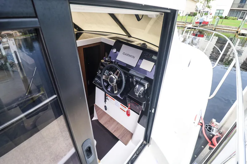 Slide: The Image of 2021 Jeanneau NC 1095 helm with Garmin navigation system, docked by water. - 8