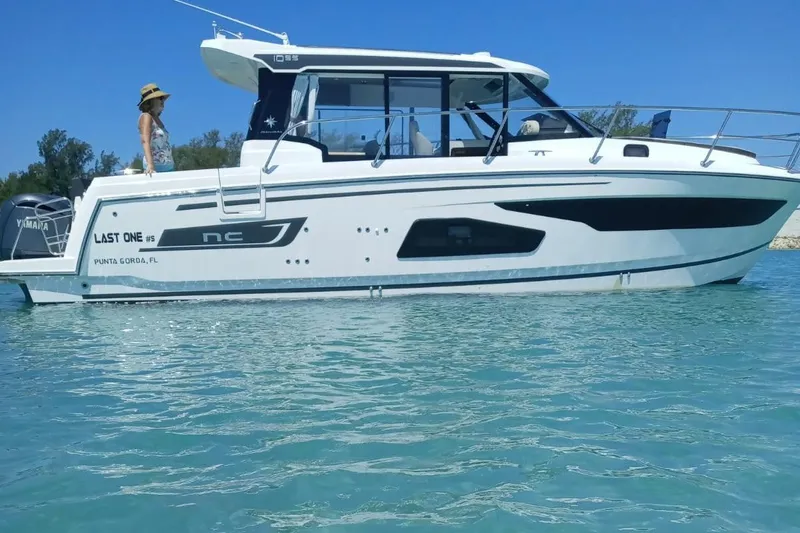 The Image of 2021 Jeanneau NC 1095 boat on clear water with a person on deck. - 0