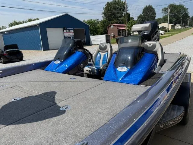 Slide: The Image of 2018 Phoenix 920 ProXP boat with blue accents, parked outdoors near a blue building. - 8