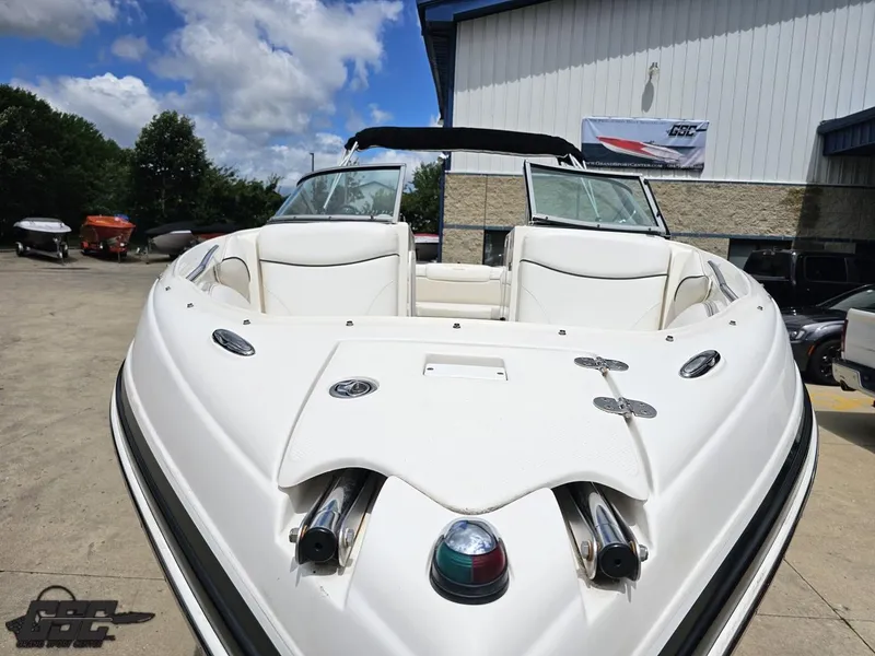 Slide: The Image of 2007 Rinker 246 Captiva Bowrider boat with white interior, parked outdoors under a blue sky. - 11