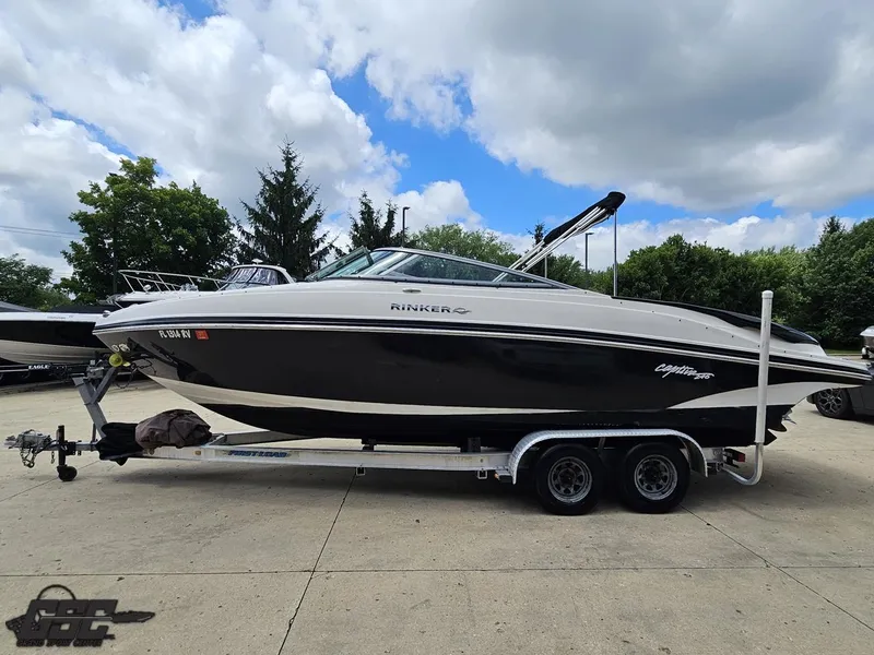 Slide: The Image of 2007 Rinker 246 Captiva Bowrider on trailer, parked outdoors under cloudy sky. - 17