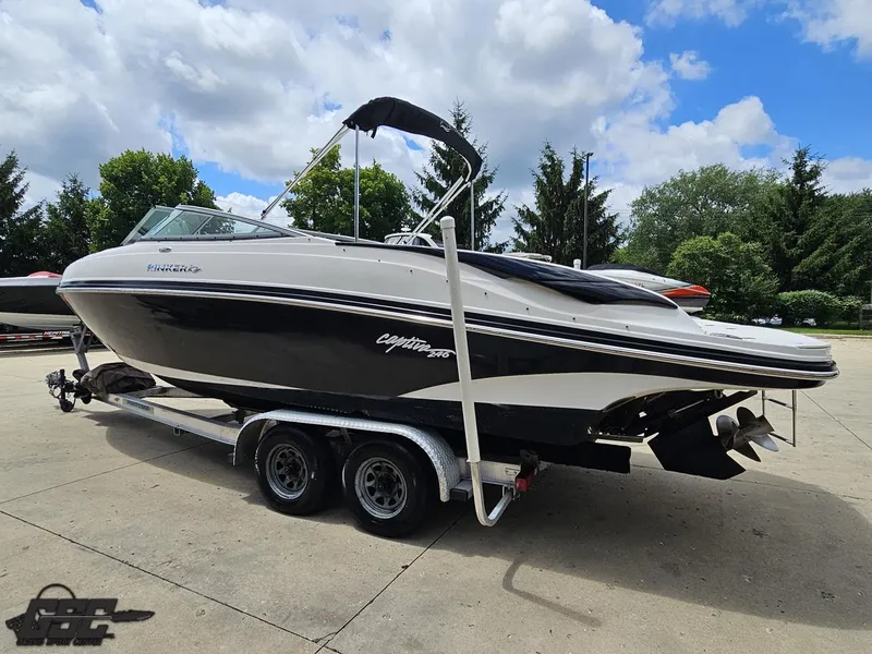 Slide: The Image of 2007 Rinker 246 Captiva Bowrider boat on trailer under cloudy sky. - 24