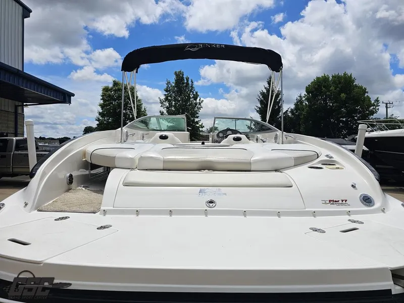 Slide: The Image of 2007 Rinker 246 Captiva Bowrider boat with canopy, parked outdoors under a blue sky. - 28