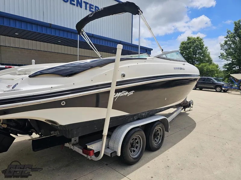 Slide: The Image of 2007 Rinker 246 Captiva Bowrider on trailer, parked outside a building under a blue sky. - 30
