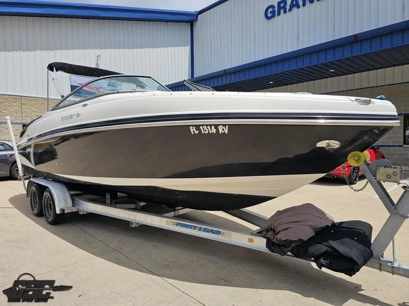 Slide: The Image of 2007 Rinker 246 Captiva Bowrider on trailer outside a building. - 9