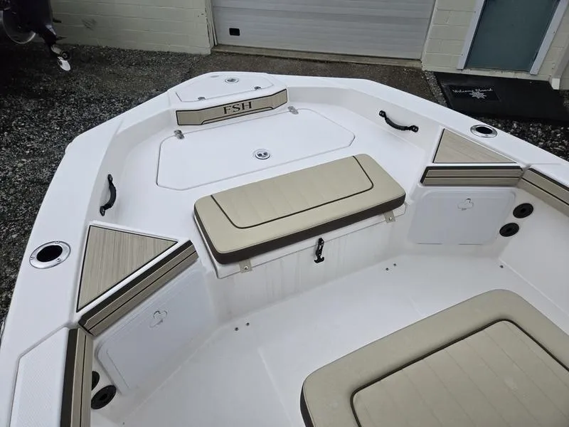 Slide: The Image of 2022 Yamaha Boats 195 FSH® SPORT interior with beige seating and storage compartments. - 17
