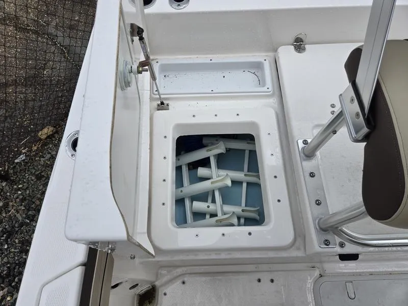 Slide: The Image of 2022 Yamaha Boats 195 FSH® SPORT storage compartment with open lid and accessories inside. - 5