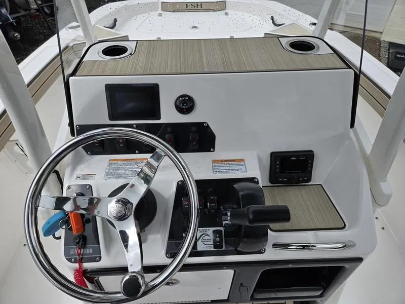 Slide: The Image of 2022 Yamaha Boats 195 FSH® SPORT helm with steering wheel and control panel. - 9