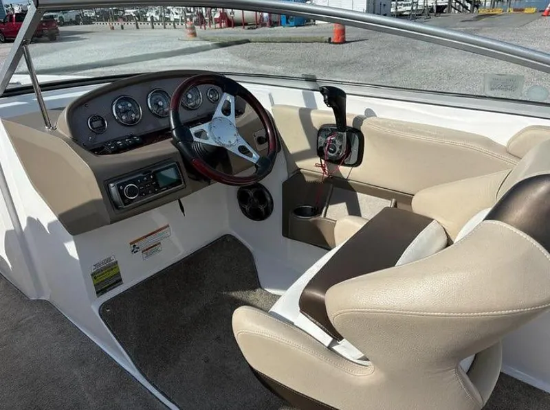 Slide: The Image of 2013 Regal 2000 ES boat interior with steering wheel, dashboard, and beige seating. - 4