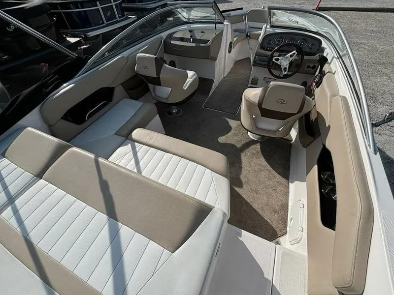 Slide: The Image of 2013 Regal 2000 ES boat interior with beige and white seating, steering wheel, and dashboard. - 7