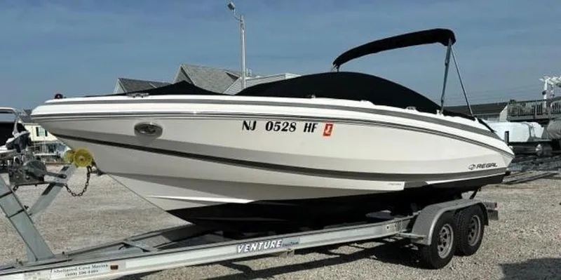 Slide: The Image of 2013 Regal 2000 ES boat on trailer, white hull, black canopy, parked outdoors. - 8