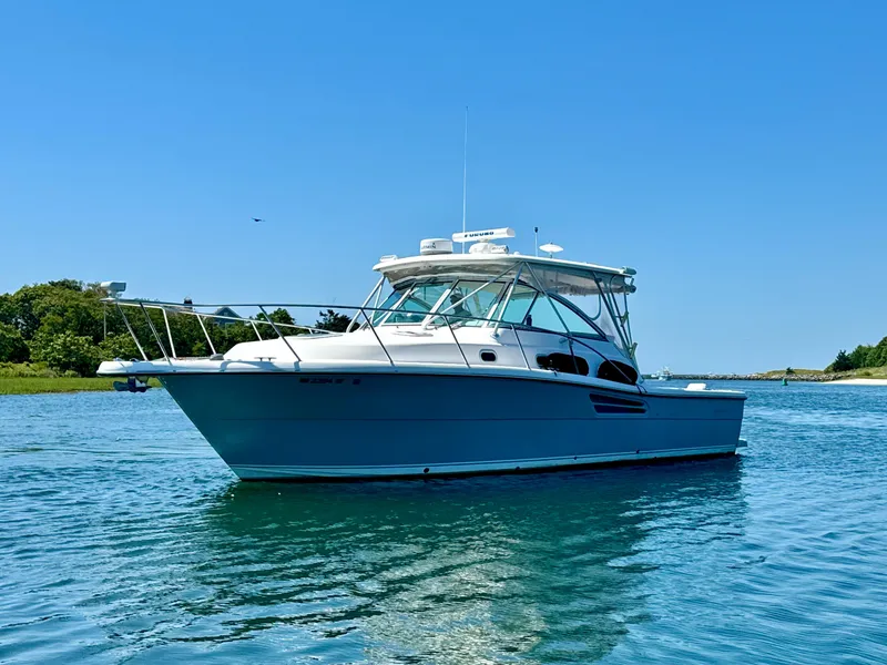 The Image of 2003 Pursuit 3400 Express boat on calm water under clear blue sky. - 1