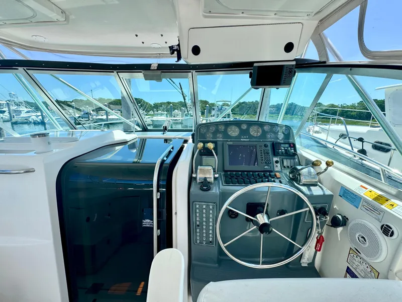 Slide: The Image of 2003 Pursuit 3400 Express boat cockpit with steering wheel and navigation controls. - 15