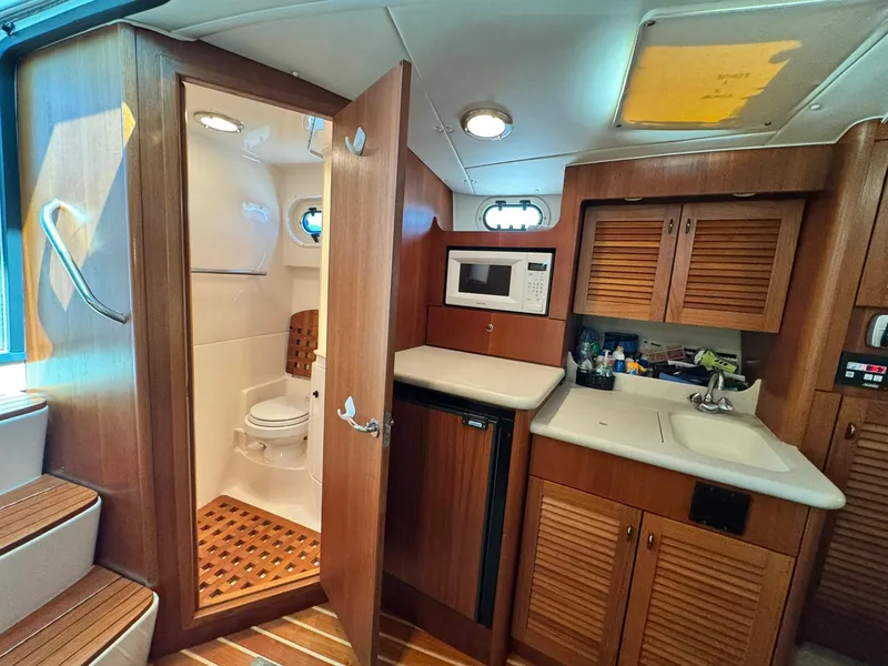 Slide: The Image of 2003 Pursuit 3400 Express cabin interior with kitchenette and bathroom. - 20