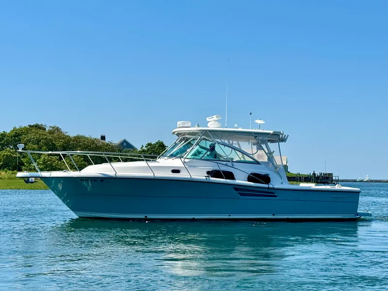 Slide: The Image of 2003 Pursuit 3400 Express boat on calm water under clear blue sky. - 8