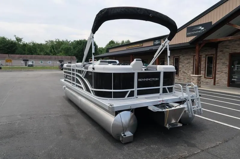 Slide: The Image of 2026 Bennington S Quad Bench 20 SSR boat interior with stylish seating in a parking lot. - 12