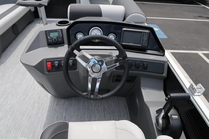 Slide: The Image of 2026 Bennington S Quad Bench 20 SSR boat interior with captain's chair and dashboard. - 16