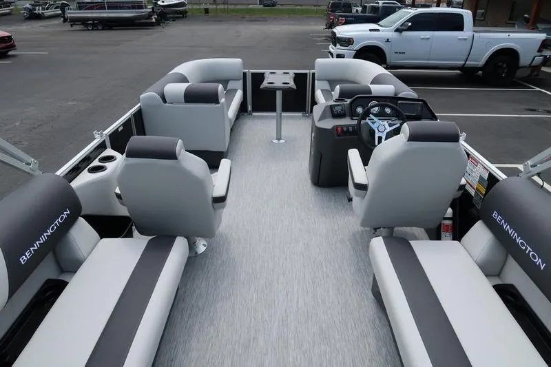 Slide: The Image of 2026 Bennington S Quad Bench 20 SSR with cupholder table in a parking lot. - 19