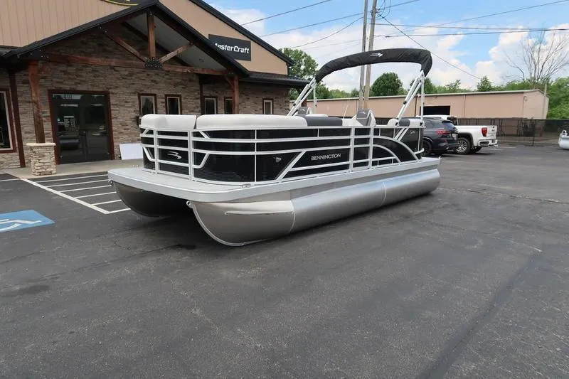Slide: The Image of 2026 Bennington S Quad Bench 20 SSR pontoon boat parked outside dealership. - 4