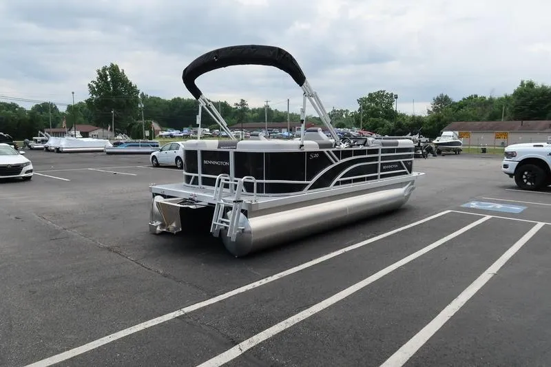 Slide: The Image of 2026 Bennington S Quad Bench 20 SSR pontoon boat in parking lot, overcast sky. - 6