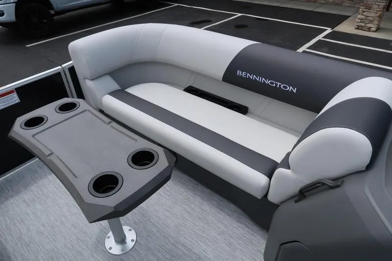 Slide: The Image of 2026 Bennington S Quad Bench 20 SSR boat interior with seating and cup holder table. - 9