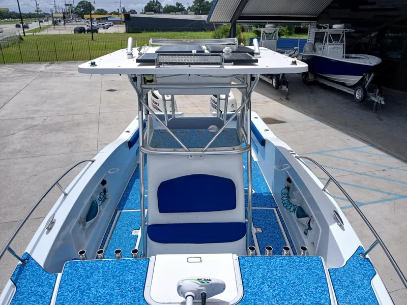 Slide: The Image of 2002 ProKat 2860 Center Console boat with blue deck, docked outdoors. - 13