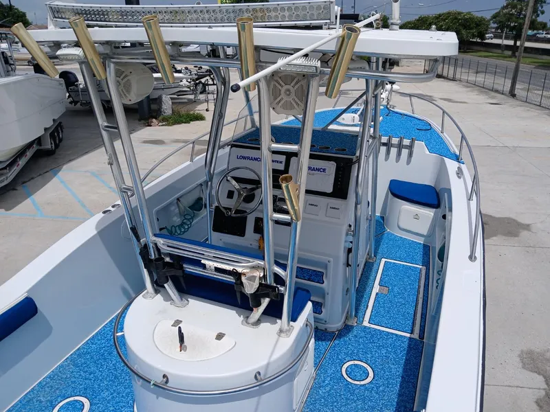 Slide: The Image of 2002 ProKat 2860 Center Console boat with blue deck, rod holders, and navigation equipment. - 2