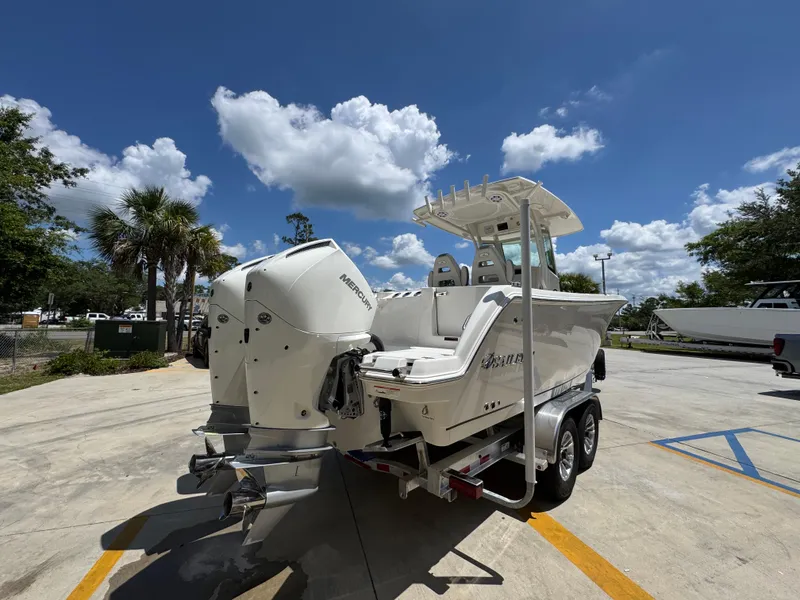Slide: The Image of 2026 Sailfish 272 CC boat with dual Mercury engines on a trailer under a clear blue sky. - 15