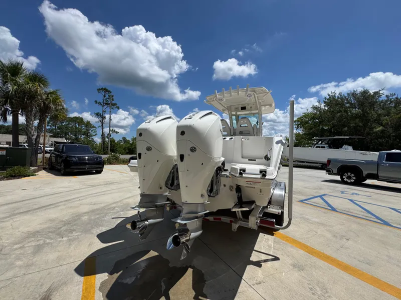 Slide: The Image of 2026 Sailfish 272 CC boat with dual outboard motors in a sunny parking lot. - 16