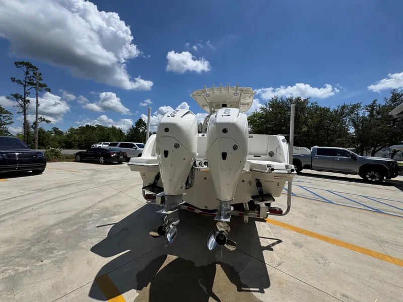 Slide: The Image of 2026 Sailfish 272 CC boat with dual outboard motors in a parking lot under a blue sky. - 17