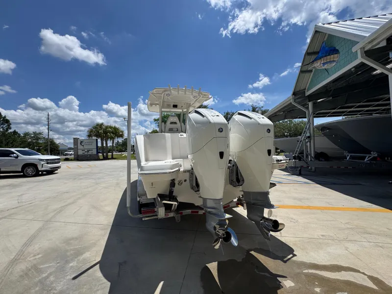 Slide: The Image of 2026 Sailfish 272 CC boat with dual outboard motors in a sunny marina setting. - 19