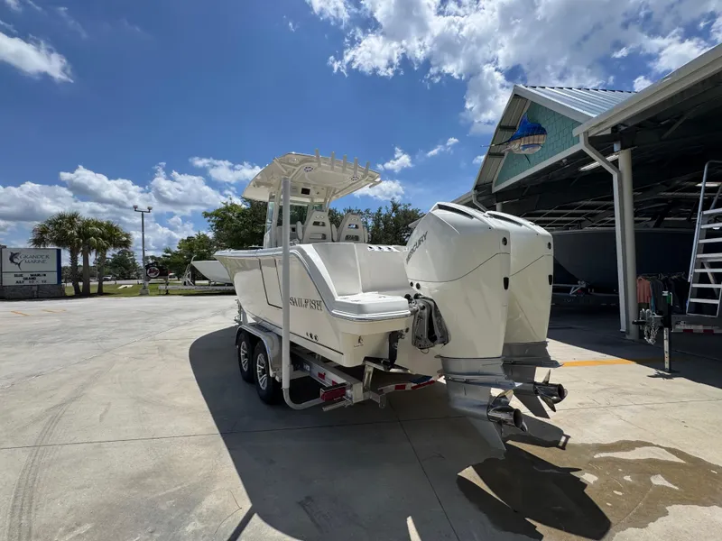 Slide: The Image of 2026 Sailfish 272 CC boat with dual engines parked outdoors under a sunny sky. - 20