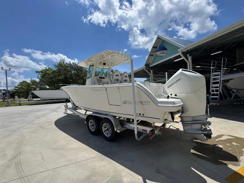 Slide: The Image of 2026 Sailfish 272 CC boat on trailer, parked outdoors under a sunny sky. - 21