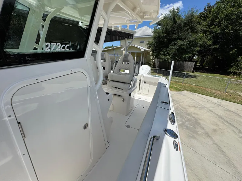 Slide: The Image of 2026 Sailfish 272 CC boat interior with seating and console, parked outdoors. - 28